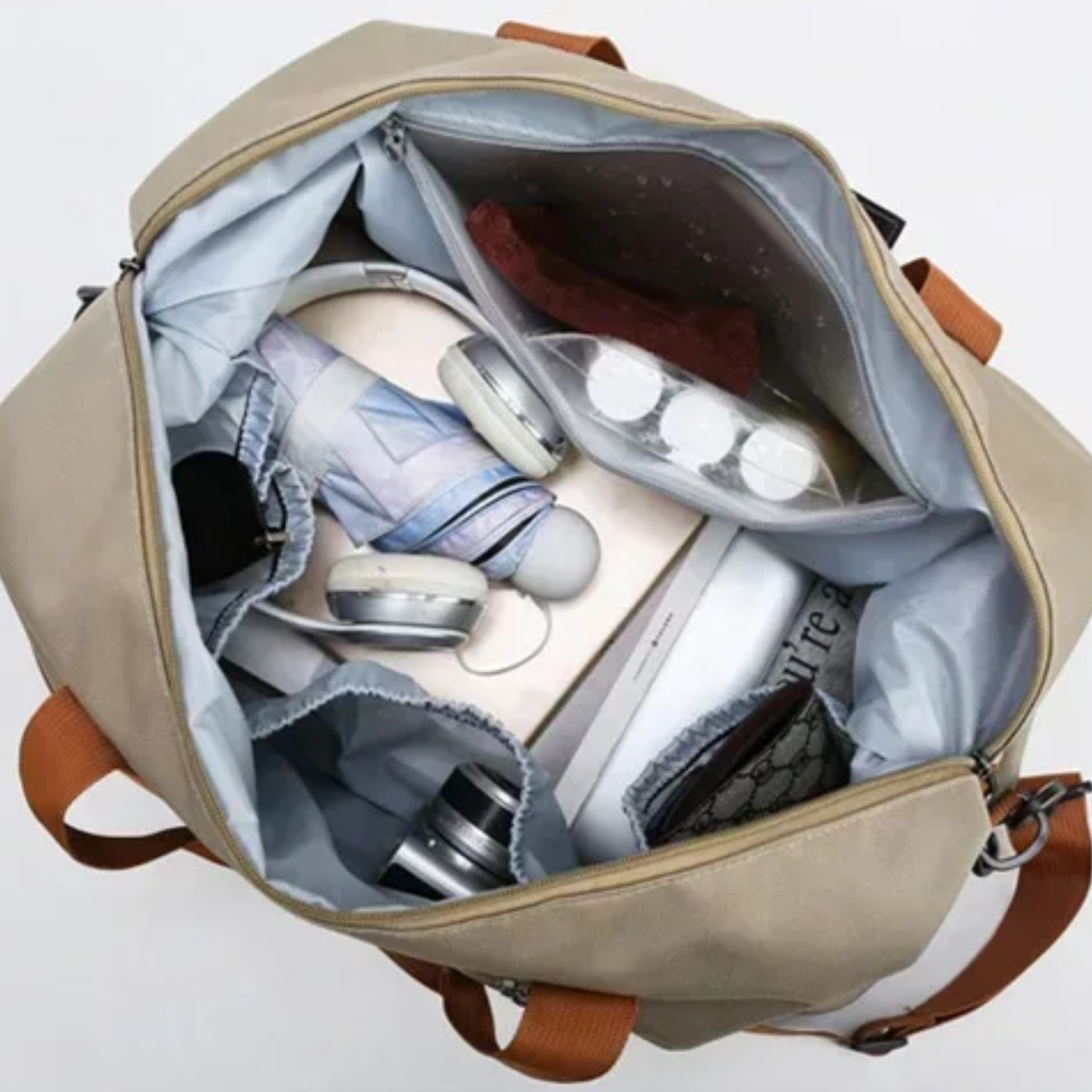 Organização interna da bolsa feminina UltraPack bege com roupas dobradas