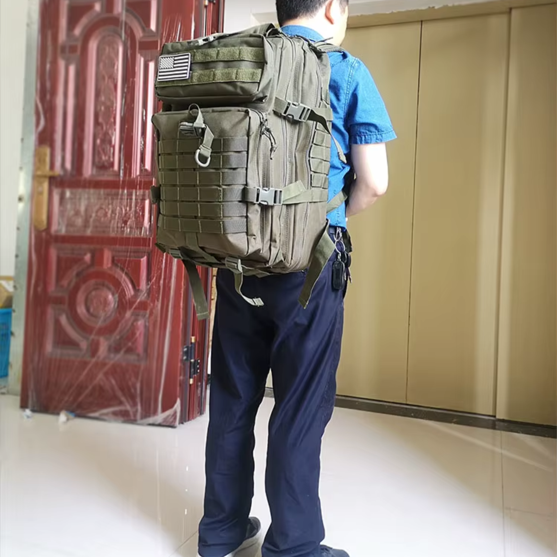 Mochila tática verde 50L vista lateral com bolsos expansíveis para acessórios