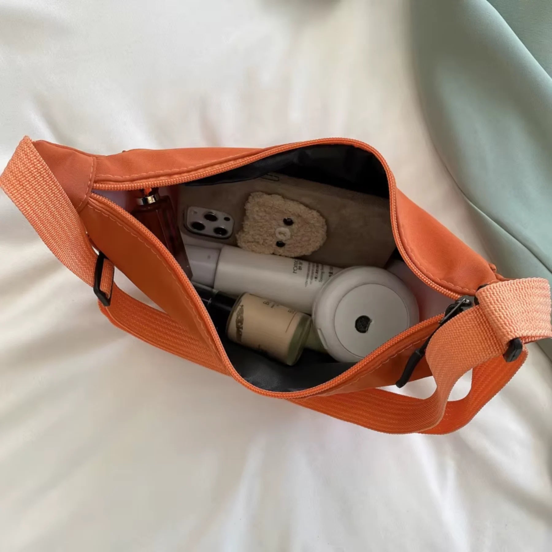 Bolsa transversal Luna Belle laranja usada na lateral do corpo