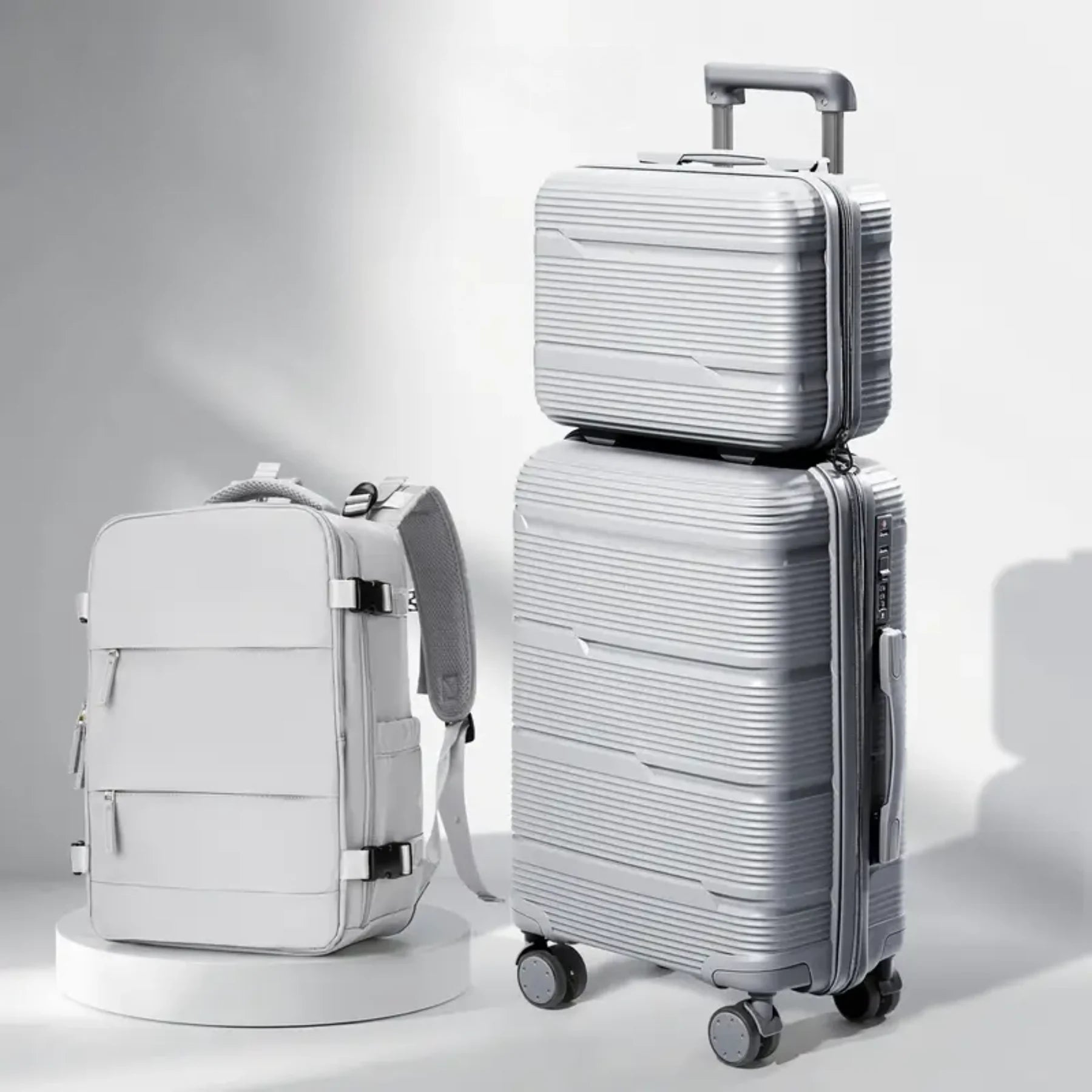 Conjunto TripVault Trio cinza empilhado na mala de rodinhas, look feminino elegante para viagem.