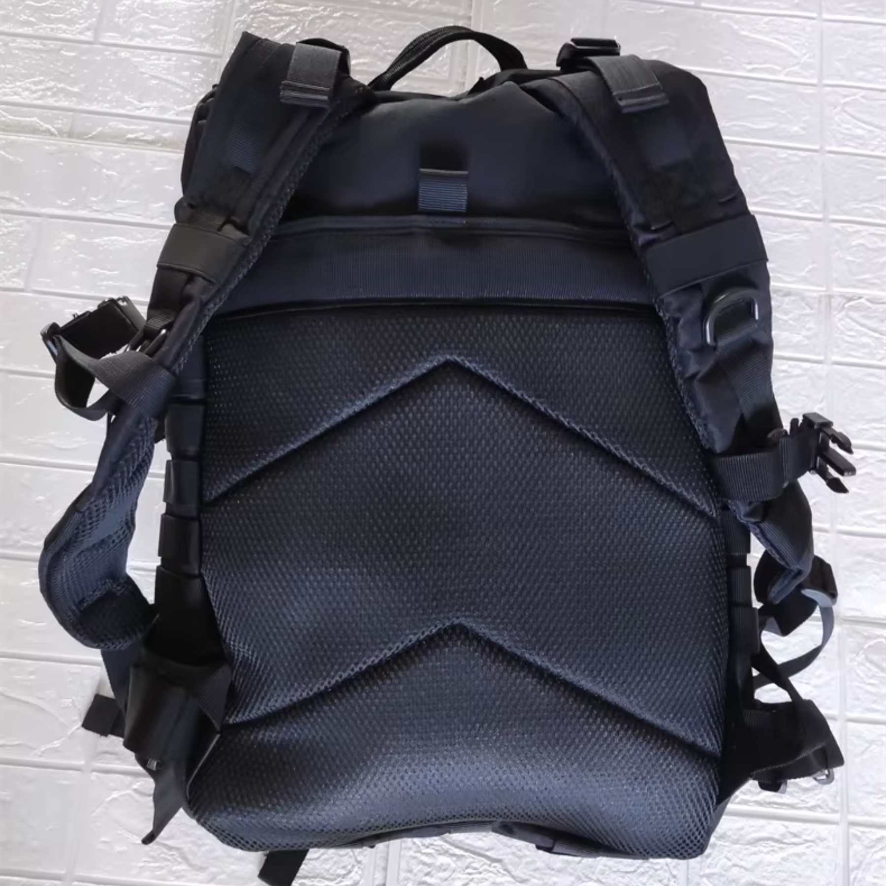 Mochila tática preta 50L impermeável em demonstração contra respingos de água